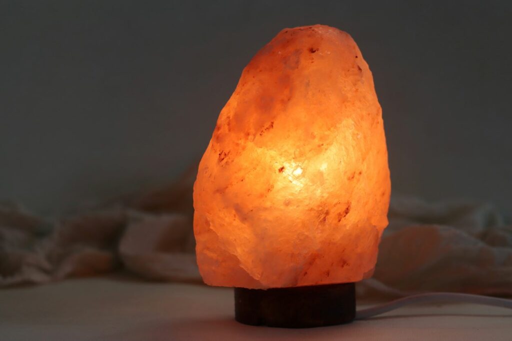 A Himalayan pink salt crystal lamp lighting up a dark room.