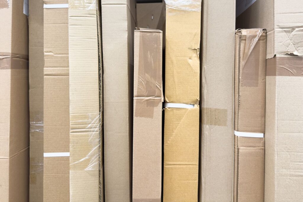 A row of tall cardboard boxes of various sizes packed tightly together.